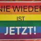 Plakat "Nie wieder ist jetzt" auf Regenbogenfarben