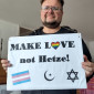Pfr. Herold mit Plakat "Make Love not Hetze" und Symbolen Transgenderflagge, Davidstern, islamischer Halbmond