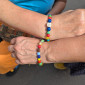 Bunte Armbänder an zwei Armen 