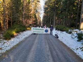 Menschen mit großem Banner auf dem steht: "Klimaschutz geht jeden an"